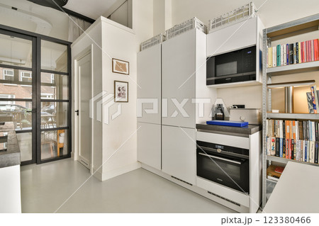 The image showcases a sleek, contemporary kitchen with minimalist cabinetry and an organized layout, emphasizing modern design elements and functionality. 123380466