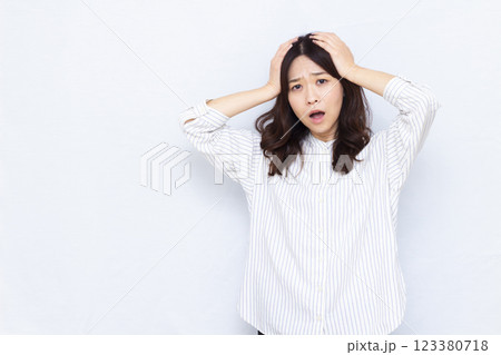 頭を抱えておどろく女性 123380718