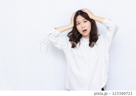 頭を抱えておどろく女性 頭を抱えておどろく女性 123380721