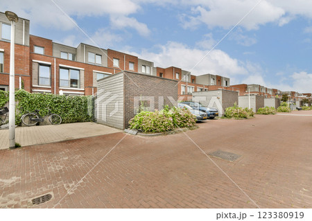 A contemporary residential area featuring modern buildings, well-maintained sidewalks, and greenery, capturing urban living's tranquility. 123380919