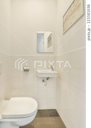 A sleek and modern bathroom featuring a clean toilet design, white tiled walls, and minimalist décor that enhances space and functionality. A sleek and modern bathroom featuring a clean toilet design, white tiled walls, and minimalist décor that enhances space and functionality. 123381036