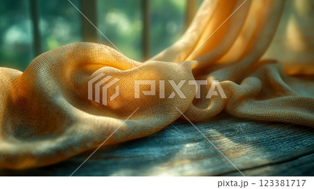Textured fabric drapes softly over a rustic wooden surface in warm sunlight. Generative AI 123381717