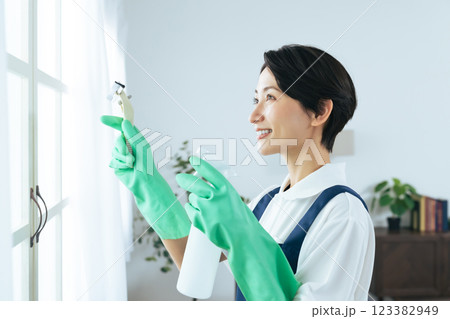 リビングルームで清掃道具を持つミドル女性 123382949