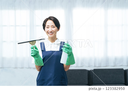 リビングルームで清掃道具を持つミドル女性 123382950