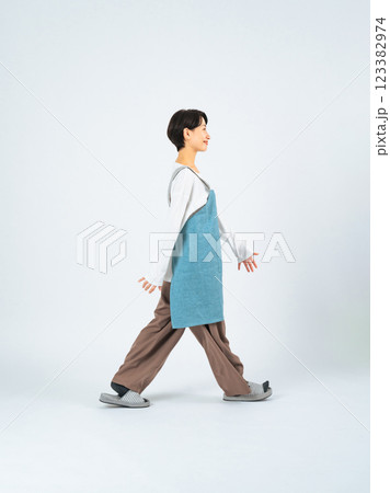 エプロンをつけて歩くミドル女性の全身写真 123382974