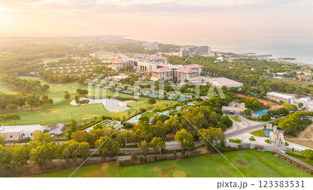 Aerial panoramic view of a luxury seaside resort with golf courses, private villas, and pools at sunrise Aerial panoramic view of a luxury seaside resort with golf courses, private villas, and pools at sunrise 123383531