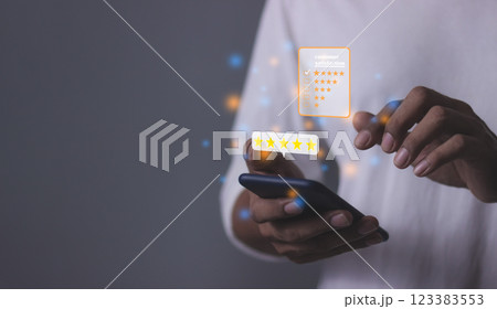 Young Man hand holding Smart Phone with five star to review and give 5 stars 123383553