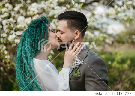 a bearded groom and a girl with green hair are walking a bearded groom and a girl with green hair are walking 123383778