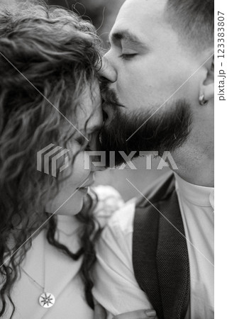 a bearded groom plays a stringed instrument and a girl sits in a spring meadow 123383807