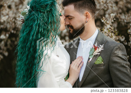 a bearded groom plays and a girl with green hair against the background of blooming spring a bearded groom plays and a girl with green hair against the background of blooming spring 123383828