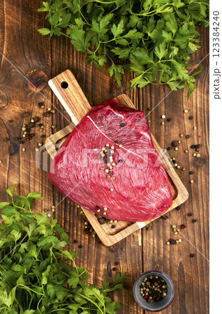 Raw beef steak on a rustic wooden board. Raw beef steak on a rustic wooden board. 123384240