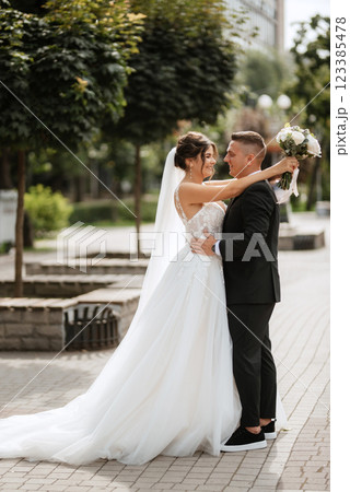 the groom in a brown suit and the bride in a white dress 123385478