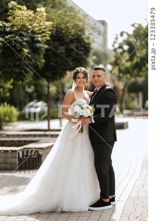 the groom in a brown suit and the bride in a white dress 123385479