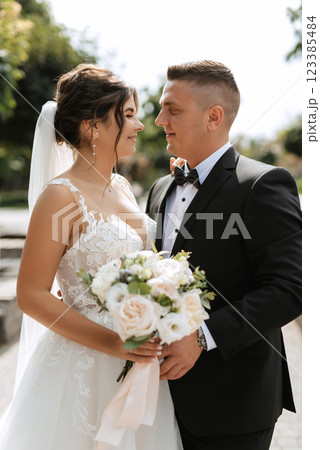 the groom in a brown suit and the bride in a white dress 123385484