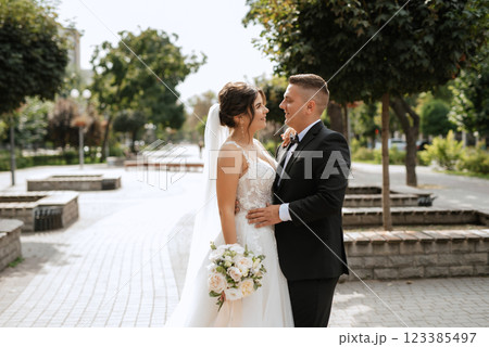 the groom in a brown suit and the bride in a white dress 123385497