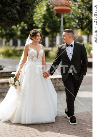 the groom in a brown suit and the bride in a white dress 123385516