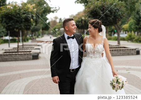 the groom in a brown suit and the bride in a white dress 123385524