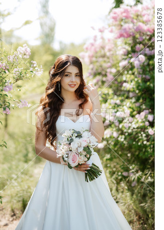 young girl bride in a white dress in a spring forest in lilac bushes young girl bride in a white dress in a spring forest in lilac bushes 123385678