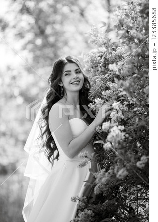 young girl bride in a white dress in a spring forest in lilac bushes young girl bride in a white dress in a spring forest in lilac bushes 123385688