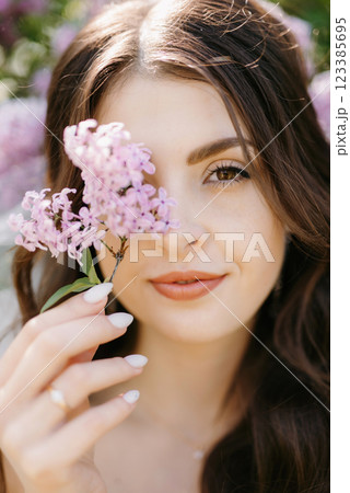 young girl bride in a white dress in a spring forest in lilac bushes young girl bride in a white dress in a spring forest in lilac bushes 123385695