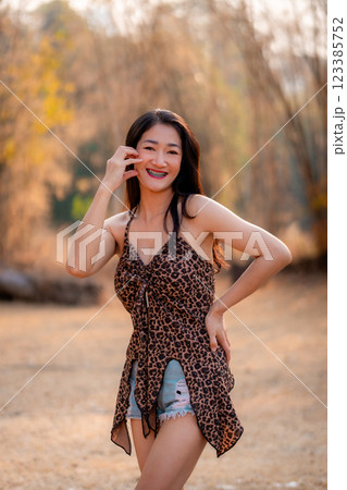 Portrait of sexy asian woman in a military print strapless dress, camping in the forest concept. Portrait of sexy asian woman in a military print strapless dress, camping in the forest concept. 123385752