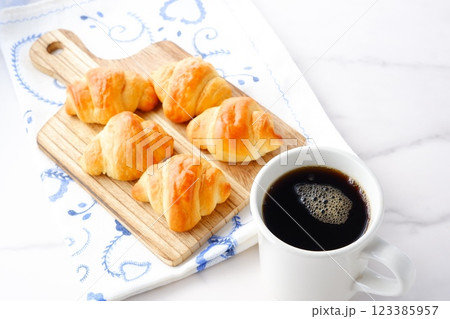 焼き立てでサクサクの食感のクロワッサンと、淹れたてのコーヒーの朝食 123385957