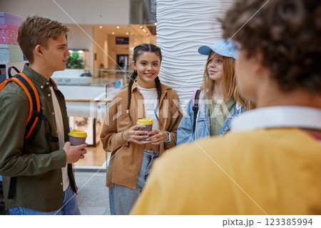 Teenagers smiling and talking at shopping mall food court Teenagers smiling and talking at shopping mall food court 123385994