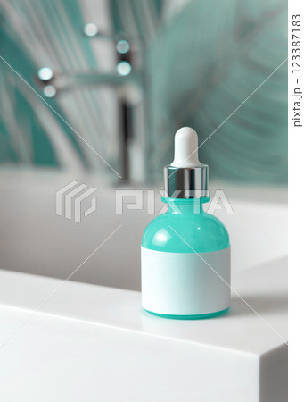 Blue glass dropper bottle with pipette on washbasin in green bathroom close up cosmetic mockup Blue glass dropper bottle with pipette on washbasin in green bathroom close up cosmetic mockup 123387183