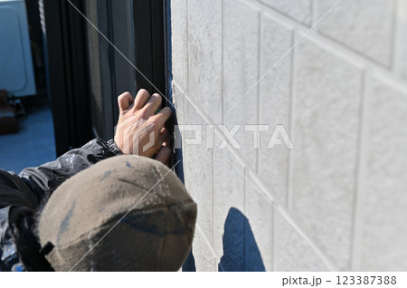 マスキングをする職人 コーキング打ち替え 外壁塗装工事 マスキングをする職人 コーキング打ち替え 外壁塗装工事 123387388