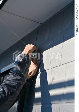 マスキングをする職人　コーキング打ち替え　外壁塗装工事 123387392