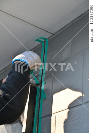 マスキングをする職人　コーキング打ち替え　外壁塗装工事 123387396