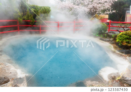 Kamado Jigoku blue hot spring with rain, gas and sakura, Beppu Kamado Jigoku blue hot spring with rain, gas and sakura, Beppu 123387430