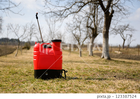 Red sprayer in spring garden 123387524