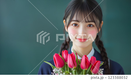 黒板の前で花束を持つ学生 123388032