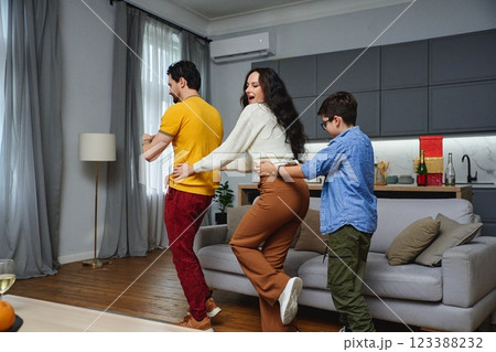 Family having fun dancing together in a cozy living room during the day 123388232