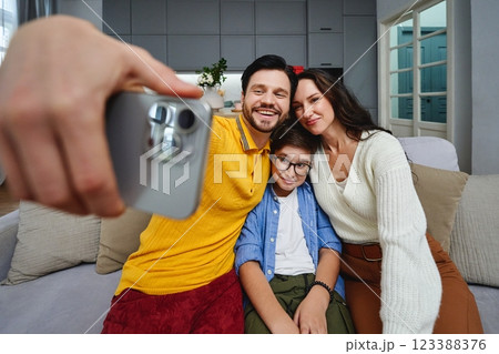 Family taking a joyful selfie together in a cozy living room setting 123388376