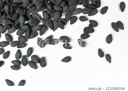 Black sesame seeds scattered on a white background macro top view 123388504