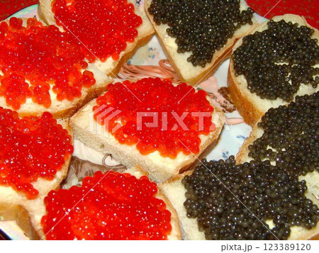 Red and black caviar over red background 123389120