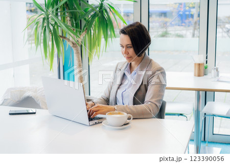 Portrait of concentrated 50's confident mature businesswoman, middle-aged experienced senior female professional working on laptop in open space office. Female entrepreneur working remotely 123390056