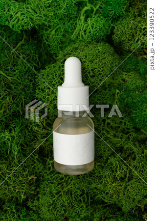 Organic skincare facial serum glass bottles with pipette on green moss background Organic skincare facial serum glass bottles with pipette on green moss background 123390522