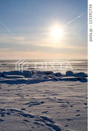 A large body of water with a bright sun in the sky 123391739