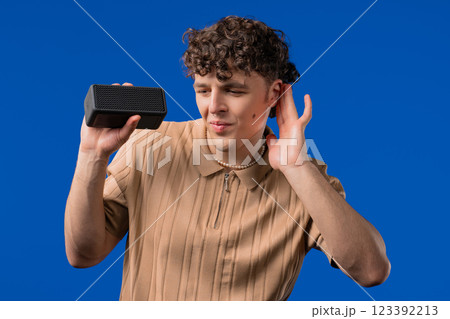 Curly haired Handsome Man Listening Music Wireless Portable Speaker Sound System Curly haired Handsome Man Listening Music Wireless Portable Speaker Sound System 123392213