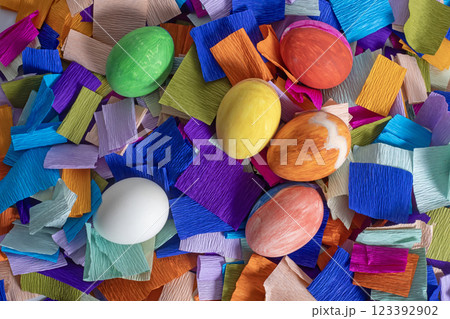 Colorful Easter eggs on a background of bright crepe paper strips Colorful Easter eggs on a background of bright crepe paper strips 123392902