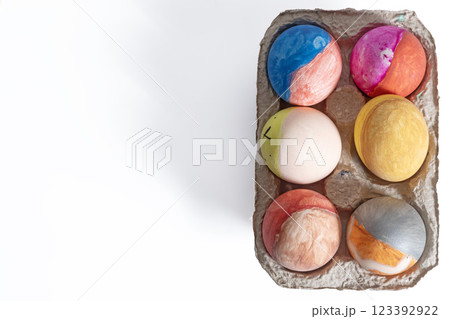 Colorful decorated Easter eggs in a cardboard box on a white background Colorful decorated Easter eggs in a cardboard box on a white background 123392922