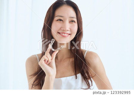 マウスピース矯正を持つ女性 マウスピース矯正を持つ女性 123392995