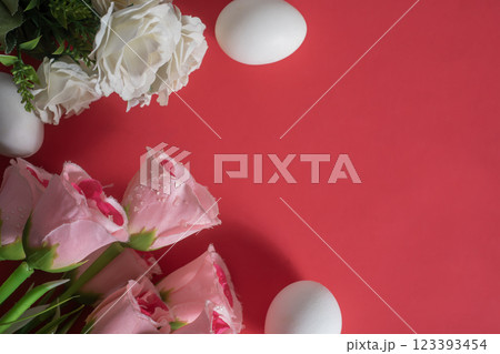 Elegant pink and white roses and white eggs on a vibrant red background. Perfect for Easter celebrations. 123393454