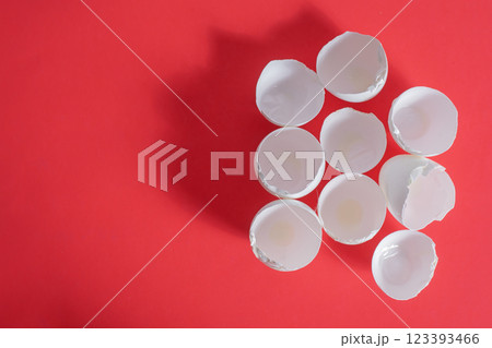 Broken eggshells arranged on a vibrant red background. Top view Broken eggshells arranged on a vibrant red background. Top view 123393466