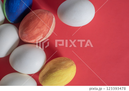Brightly colored Easter eggs on a vibrant red background. Top view Brightly colored Easter eggs on a vibrant red background. Top view 123393478