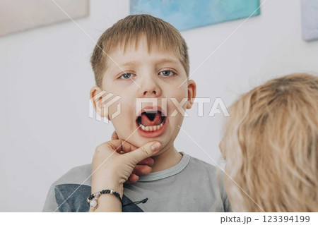 boy, tongue movement during speech therapy session, receiving professional guidance, concept of articulation training and speech correction boy, tongue movement during speech therapy session, receiving professional guidance, concept of articulation training and speech correction 123394199