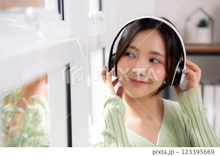 Portrait happy young woman wearing headphones listening music while standing with fun and enjoy. Portrait happy young woman wearing headphones listening music while standing with fun and enjoy. 123395669